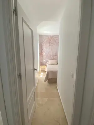 a hallway with a room with a bed and a door at Villa Tropical a 2 minutos del Faro de Chipiona in Chipiona