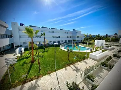 a large apartment building with a pool and palm trees at MyChoice Diana in Rota