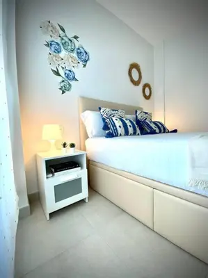 a bedroom with a bed and a table with a lamp at MyChoice Diana in Rota