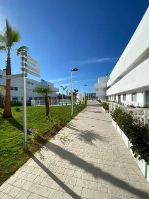 a sidewalk in front of a building with palm trees at MyChoice Diana in Rota
