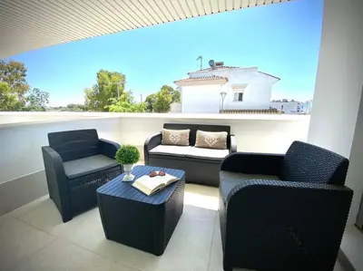 a balcony with two chairs and a couch and a table at MyChoice Diana in Rota