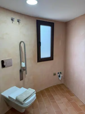 a bathroom with a toilet and a window at Hotel Bodegas Campestral in Arcos de la Frontera