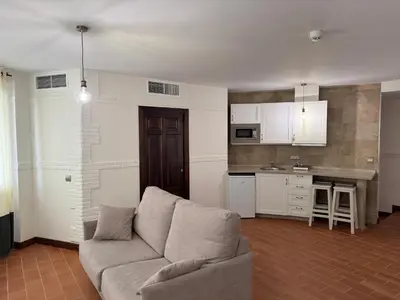 a living room with a couch and a kitchen at Hotel Bodegas Campestral in Arcos de la Frontera