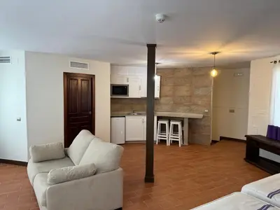 a living room with a couch and a kitchen at Hotel Bodegas Campestral in Arcos de la Frontera