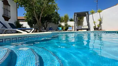 a swimming pool with blue water in a resort at HAPPY HOMES CASA LIMÓN - Premium - Pool - Klimaanlage - WLAN in Chiclana de la Frontera