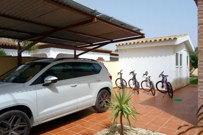 a white car parked in front of a building with bikes on it at HAPPY HOMES CASA LIMÓN - Premium - Pool - Klimaanlage - WLAN in Chiclana de la Frontera