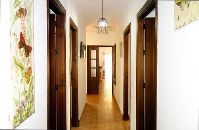 a hallway with wooden doors and a tile floor at HAPPY HOMES CASA LIMÓN - Premium - Pool - Klimaanlage - WLAN in Chiclana de la Frontera