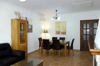 a dining room and living room with a table and chairs at HAPPY HOMES CASA LIMÓN - Premium - Pool - Klimaanlage - WLAN in Chiclana de la Frontera