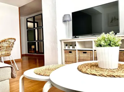 a living room with a white table and a tv at Papallona Cádiz Apartment Grupo AC Gestion in Cádiz