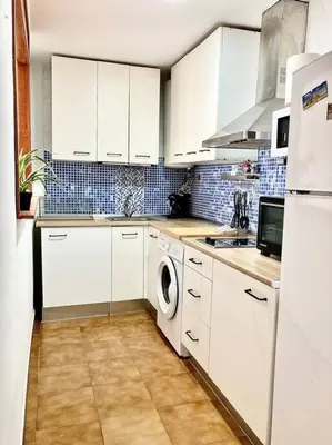 a kitchen with white cabinets and a washing machine at Papallona Cádiz Apartment Grupo AC Gestion in Cádiz
