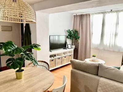 a living room with a couch and a table and a tv at Papallona Cádiz Apartment Grupo AC Gestion in Cádiz