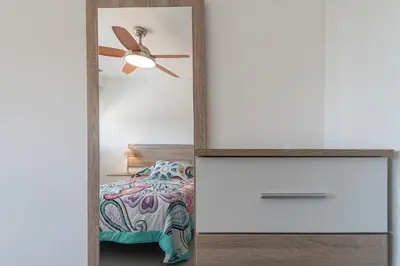 a bedroom with a mirror and a bed at Apartamento Cortadura Playa in Cádiz