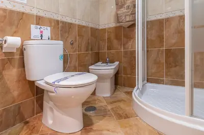 a bathroom with a toilet and a shower and a sink at Apartamento Cortadura Playa in Cádiz