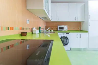 a kitchen with a sink and a washing machine at Apartamento Cortadura Playa in Cádiz