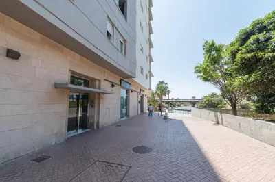 a person walking down a sidewalk next to a building at Apartamento Cortadura Playa in Cádiz