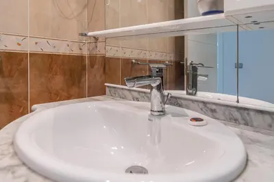 a bathroom sink with a faucet and a mirror at Apartamento Cortadura Playa in Cádiz