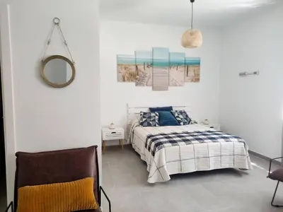 a bedroom with a bed and a mirror and a chair at Estudio Mar Azul Grupo AC Gestion in Cádiz