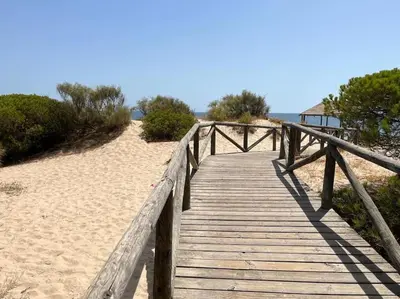 a wooden bridge over the sand on a beach at Apartamento Any en Rota in Rota