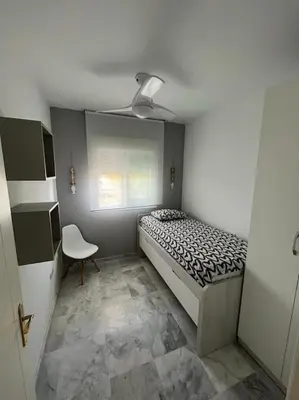 a small bedroom with a bed and a chair at Apartamento Any en Rota in Rota
