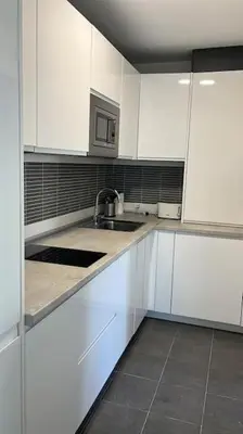 a white kitchen with white cabinets and a sink at Apartamento Any en Rota in Rota