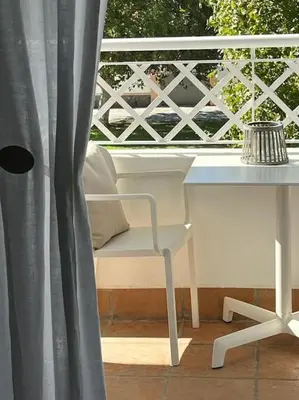 a balcony with a table and a chair and a window at Apartamento Any en Rota in Rota