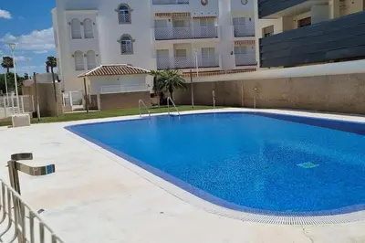 a large blue swimming pool in front of a building at Apartamento Any en Rota in Rota