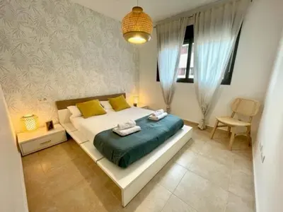 a bedroom with a large bed with yellow and green pillows at GATU PREMIUM El Viñedo, centro, parking, aire acc, terraza, piscina comun