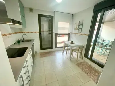a kitchen with a sink and a table in it at GATU PREMIUM El Viñedo, centro, parking, aire acc, terraza, piscina comun