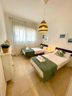 a room with two beds and a living room at GATU PREMIUM El Viñedo, centro, parking, aire acc, terraza, piscina comun