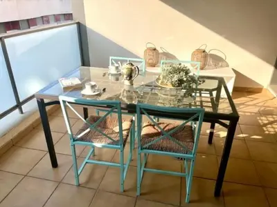 a glass table with two chairs and a glass table with a glass table at GATU PREMIUM El Viñedo, centro, parking, aire acc, terraza, piscina comun