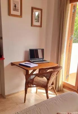 a laptop computer sitting on a wooden table in a room at Appartement à 850 m de la plage de la Barrosa in Chiclana de la Frontera