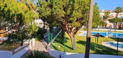 a view of a resort with a swimming pool and trees at Appartement à 850 m de la plage de la Barrosa in Chiclana de la Frontera