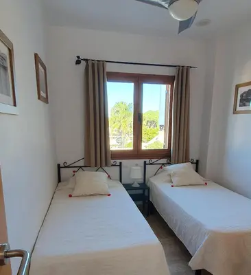 two beds in a room with a window at Appartement à 850 m de la plage de la Barrosa in Chiclana de la Frontera