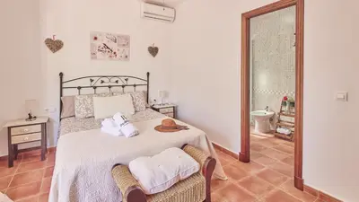 a bedroom with a bed and a chair and a window at Villa Lola 14 Chiclana de la Frontera by Ruralidays in Chiclana de la Frontera