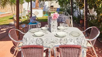 a white table with chairs and a vase of flowers at Villa Lola 14 Chiclana de la Frontera by Ruralidays in Chiclana de la Frontera