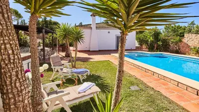 a backyard with a swimming pool and two palm trees at Villa Lola 14 Chiclana de la Frontera by Ruralidays in Chiclana de la Frontera