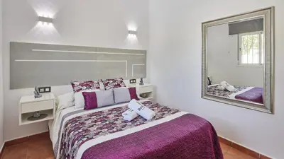 a bedroom with a large bed and a mirror at Villa Bananera Conil de la Frontera by Ruralidays in Conil de la Frontera
