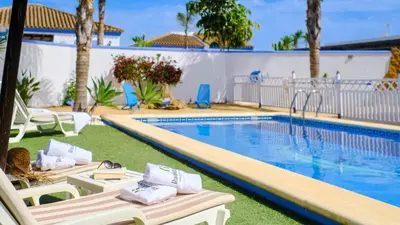 a swimming pool with two lounge chairs next to it at Villa Bananera Conil de la Frontera by Ruralidays in Conil de la Frontera