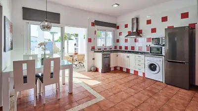 a kitchen with a refrigerator and a table in it at Villa Yuca Conil de la Frontera by Ruralidays in Conil de la Frontera