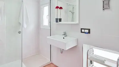 a white bathroom with a sink and a shower at Villa Yuca Conil de la Frontera by Ruralidays in Conil de la Frontera