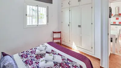 a white bedroom with a bed and a window at Villa Yuca Conil de la Frontera by Ruralidays in Conil de la Frontera