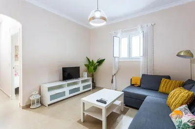 a living room with a blue couch and a tv at Corralon de los Carros by Cadiz Time in Cádiz