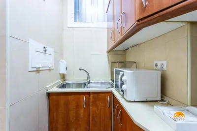 a small kitchen with a sink and a microwave at Corralon de los Carros by Cadiz Time in Cádiz