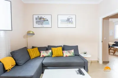 a living room with a blue couch and yellow pillows at Corralon de los Carros by Cadiz Time in Cádiz
