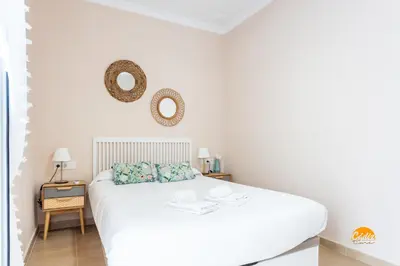 a white bedroom with a white bed and two mirrors at Corralon de los Carros by Cadiz Time in Cádiz