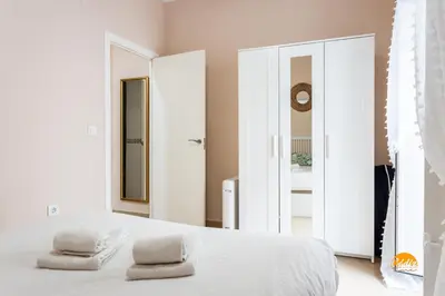 a bedroom with a white bed with two towels on it at Corralon de los Carros by Cadiz Time in Cádiz