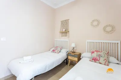 two beds in a room with white walls at Corralon de los Carros by Cadiz Time in Cádiz