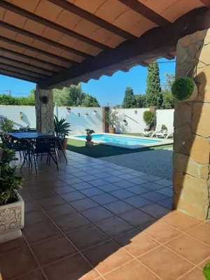 a patio with a table and chairs and a pool at Casa LA PEPA in Chiclana de la Frontera