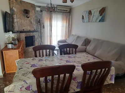 a living room with a table and chairs and a couch at Casa LA PEPA in Chiclana de la Frontera