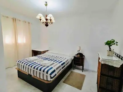 a bedroom with a bed and a chandelier at Mar Vendaval Grupo AC Gestion in Cádiz